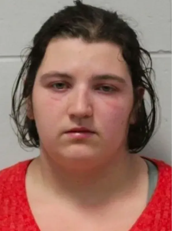 A mugshot of a young woman with dark hair and a neutral expression, wearing a red shirt.